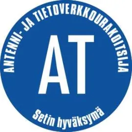 Sininen pyöreä logo, jossa on valkoiset kirjaimet AT ja teksti "ANTENNI- JA TIETOVERKKOURAKOITSIJA" sekä "Setin hyväksymä".